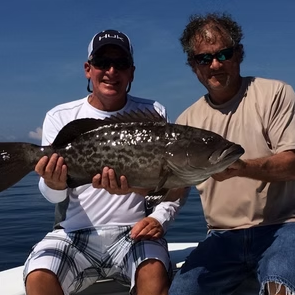Two anglers holding a trophy grouper