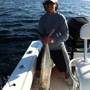 Angler with a king mackerel on the deck of the Heaven Sent